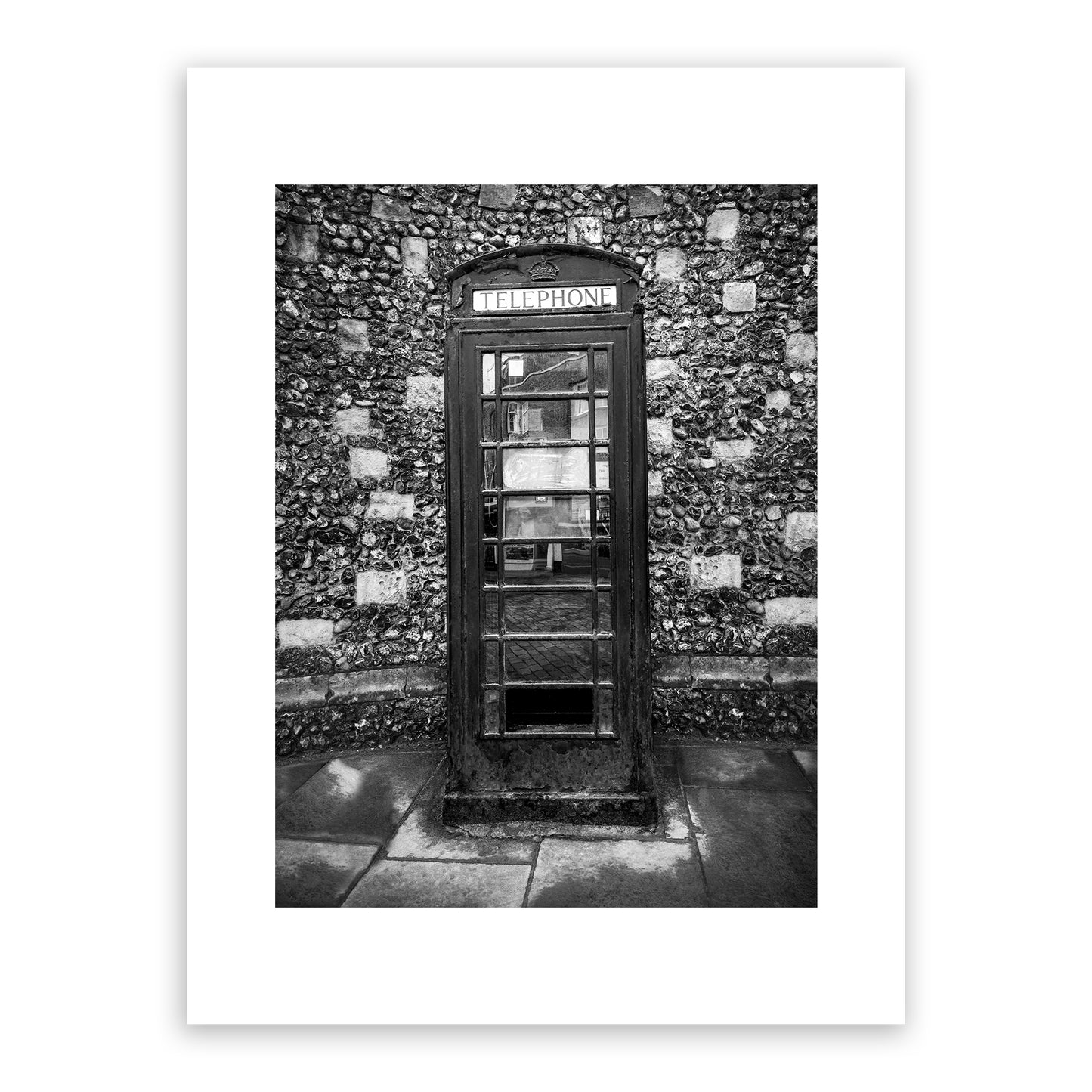 Historical telephone kiosk on the King's Mile, Canterbury, Kent, England. Designed in 1935 by Sir Gilbert Scott, introduced in 1936 to mark the jubilee of George V. The crown appearing above the door was the traditional Tudor crown. These cherished phone boxes in Canterbury are actually considered listed buildings! Fine art black and white photography print for sale.